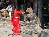 Kathmandu Valley 2 Kirtipur 05 Bagh Bhairav Temple Pilgrims At Entrance A pilgrim makes offerings at the entrance to the Bagh Bhairav Temple in Kirtipur near Kathmandu.